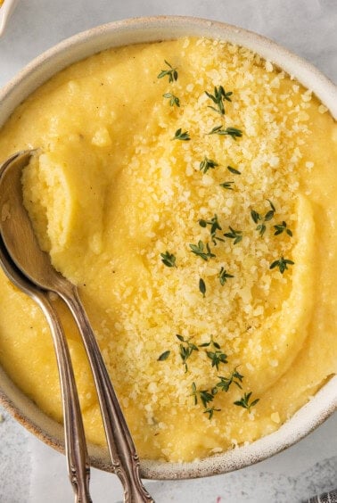 a bowl of mashed potatoes with a spoon in it.
