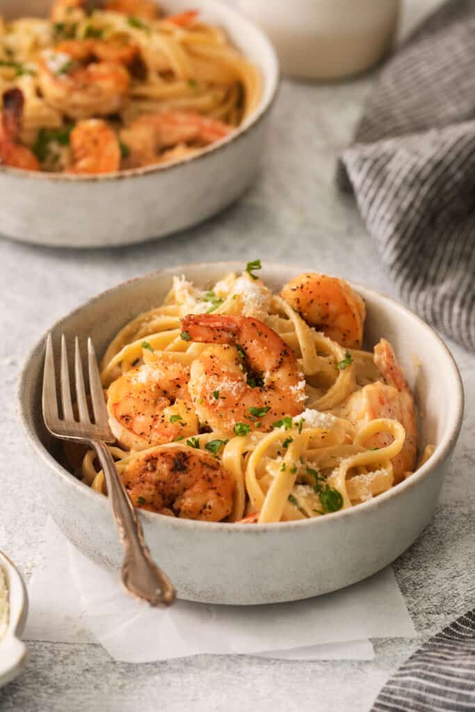 two bowls of pasta with shrimp and parmesan.