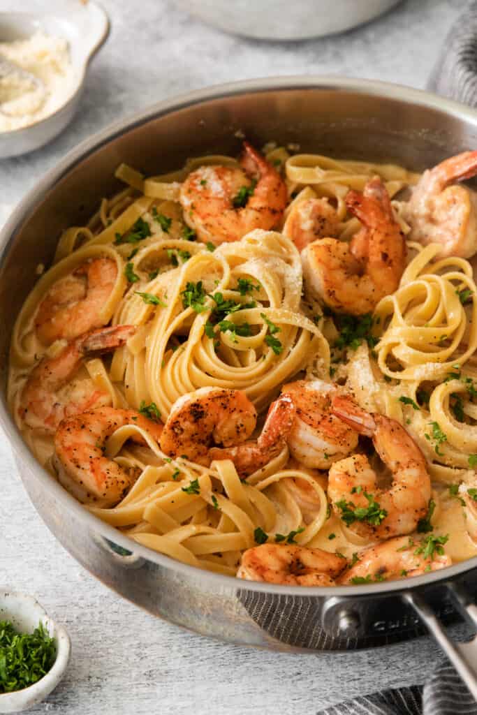 shrimp pasta in a skillet with parsley.