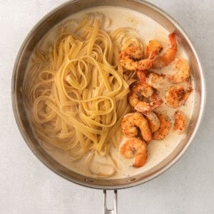 shrimp and pasta in a pan on a white background.