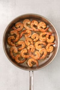 grilled shrimp in a skillet on a white background.