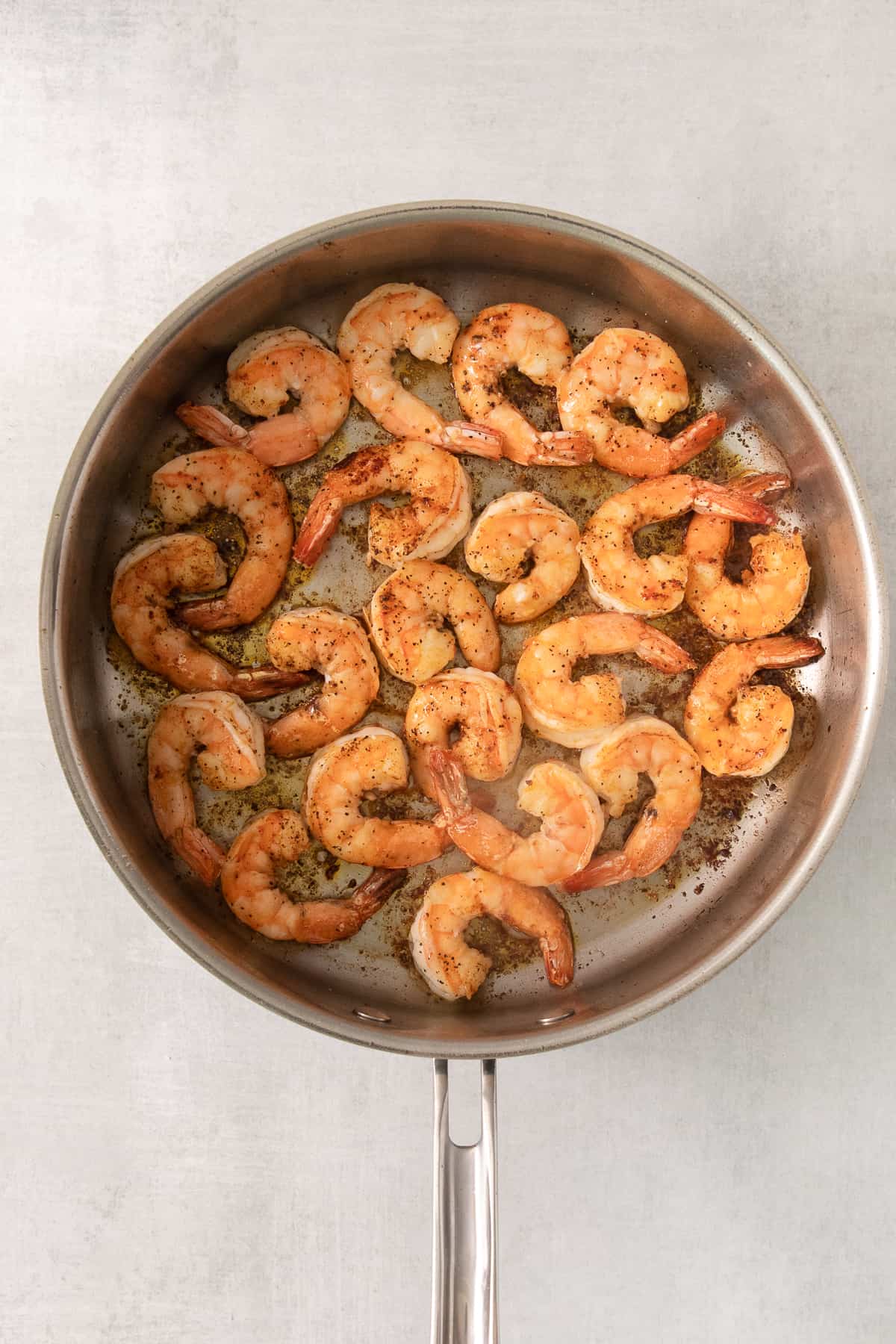 grilled shrimp in a skillet on a white background.