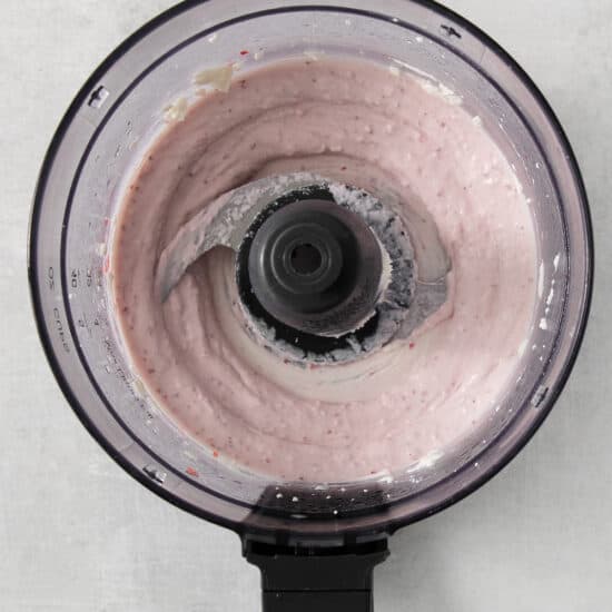 a food processor with a pink liquid in it.