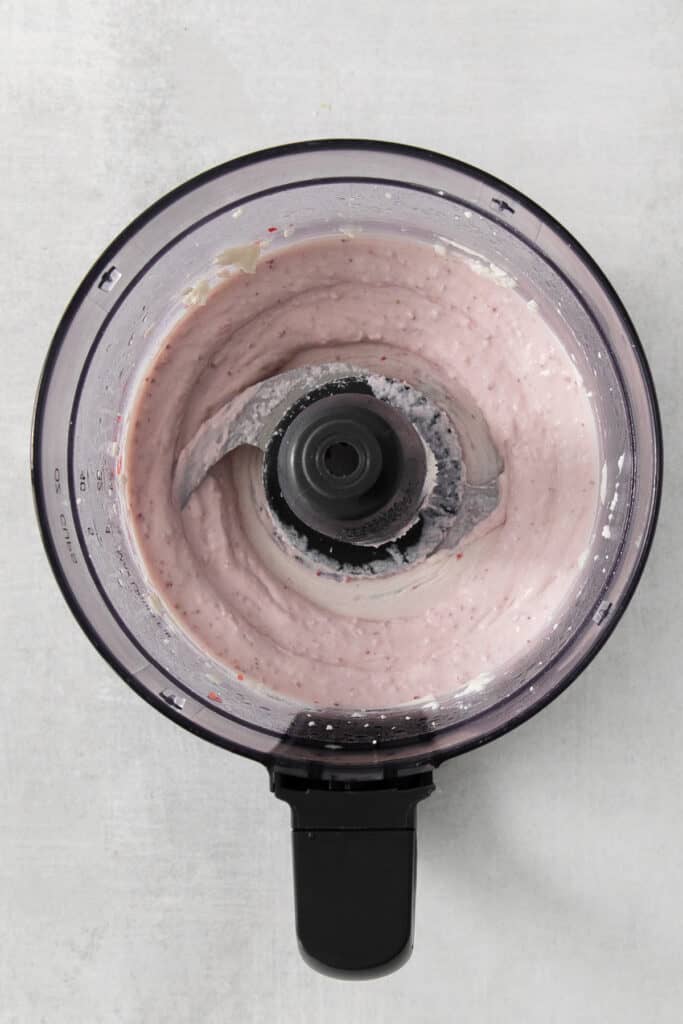 a food processor with a pink liquid in it.