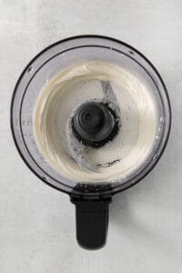 a food processor with a white liquid in it.