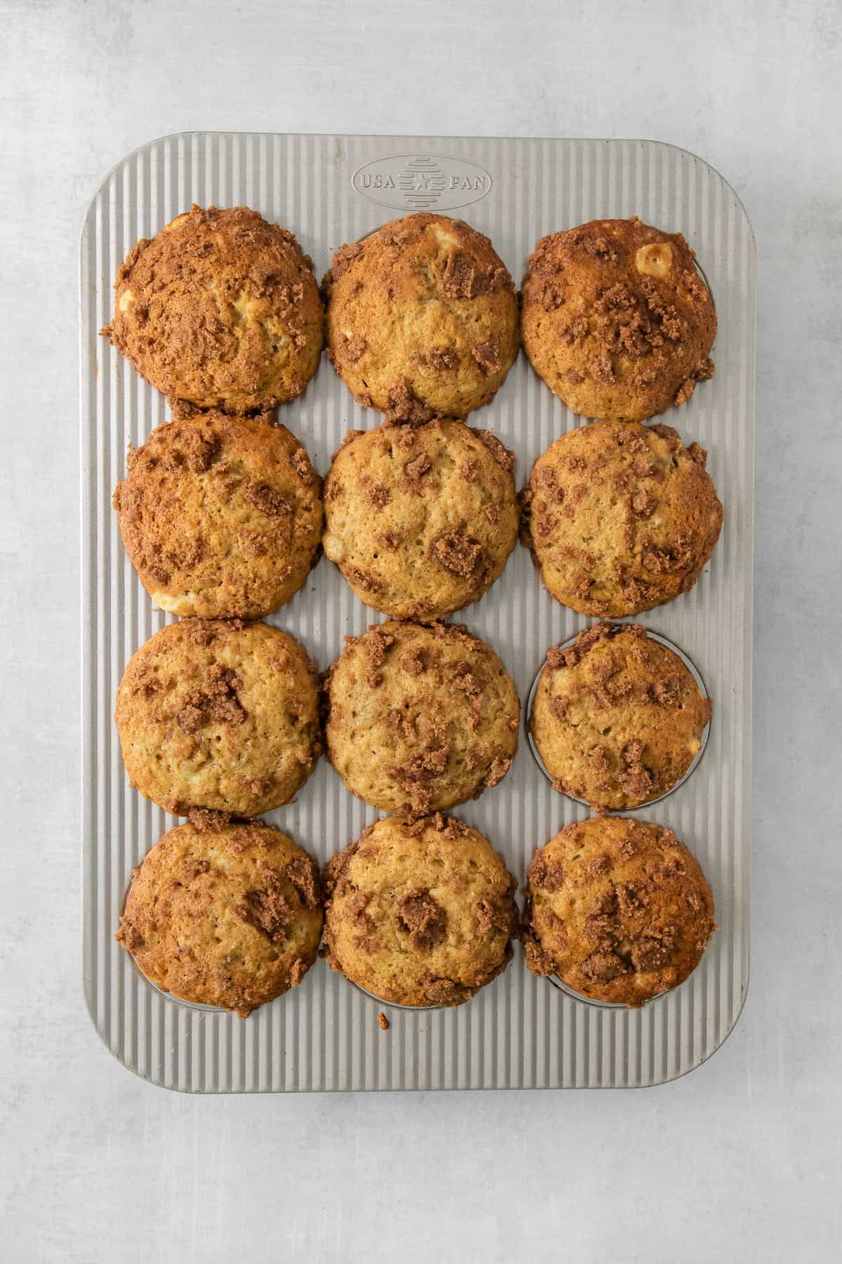 muffins in a metal pan on a grey background.