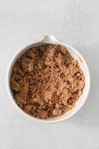 cocoa powder in a white bowl on a white background.