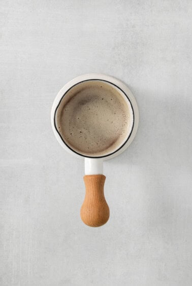 a coffee mug with a wooden handle on it.