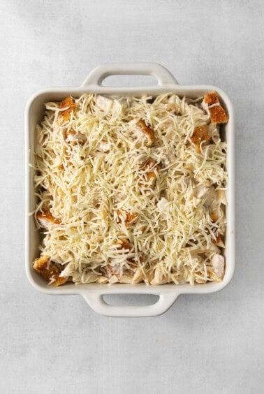 a casserole dish filled with cheese and chicken.