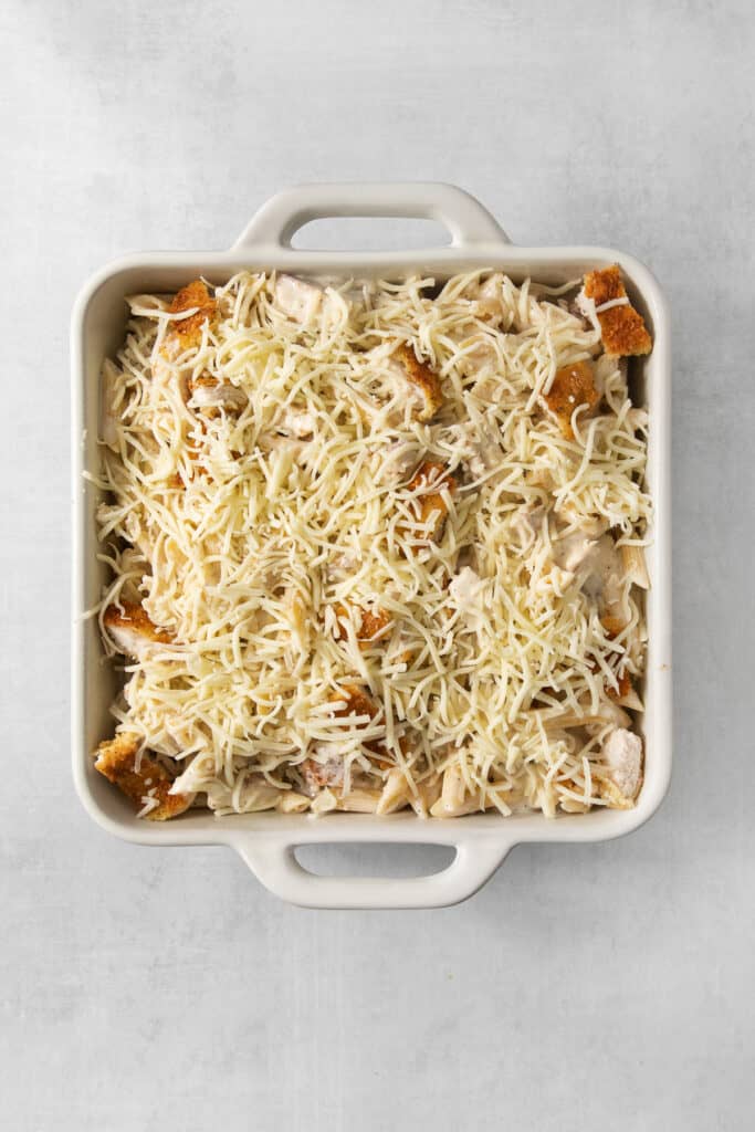 a casserole dish filled with cheese and chicken.