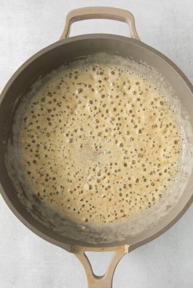 a frying pan with a brown liquid in it.