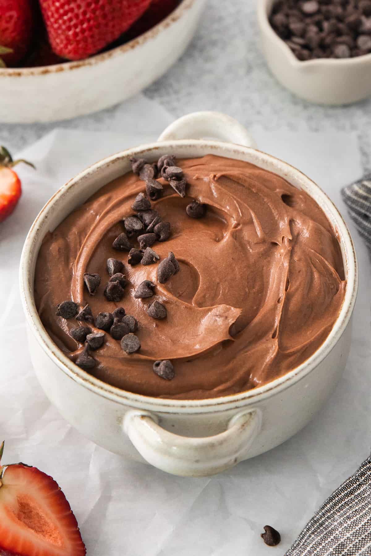 a bowl of chocolate pudding with chocolate chips on top.