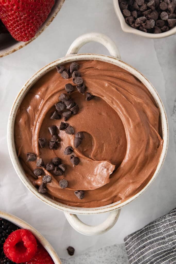 a bowl of chocolate pudding with chocolate chips on top.