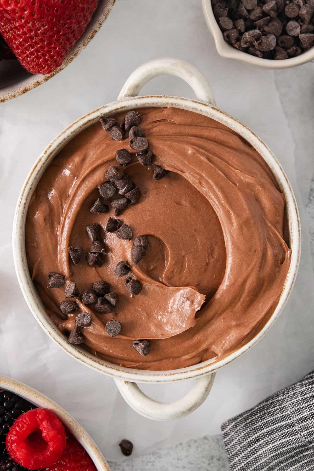 a bowl of chocolate pudding with chocolate chips on top.