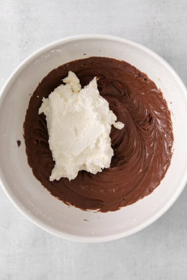 a white bowl filled with chocolate and whipped cream.