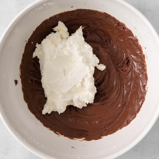 a white bowl filled with chocolate and whipped cream.