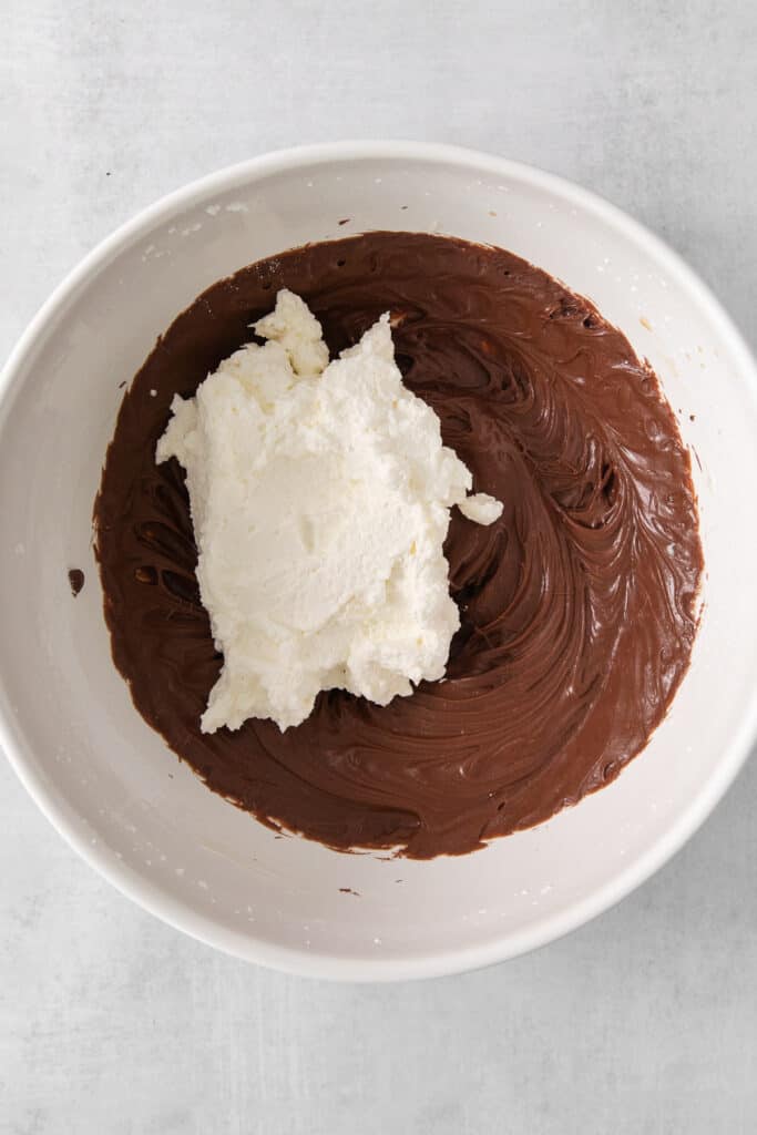 a white bowl filled with chocolate and whipped cream.