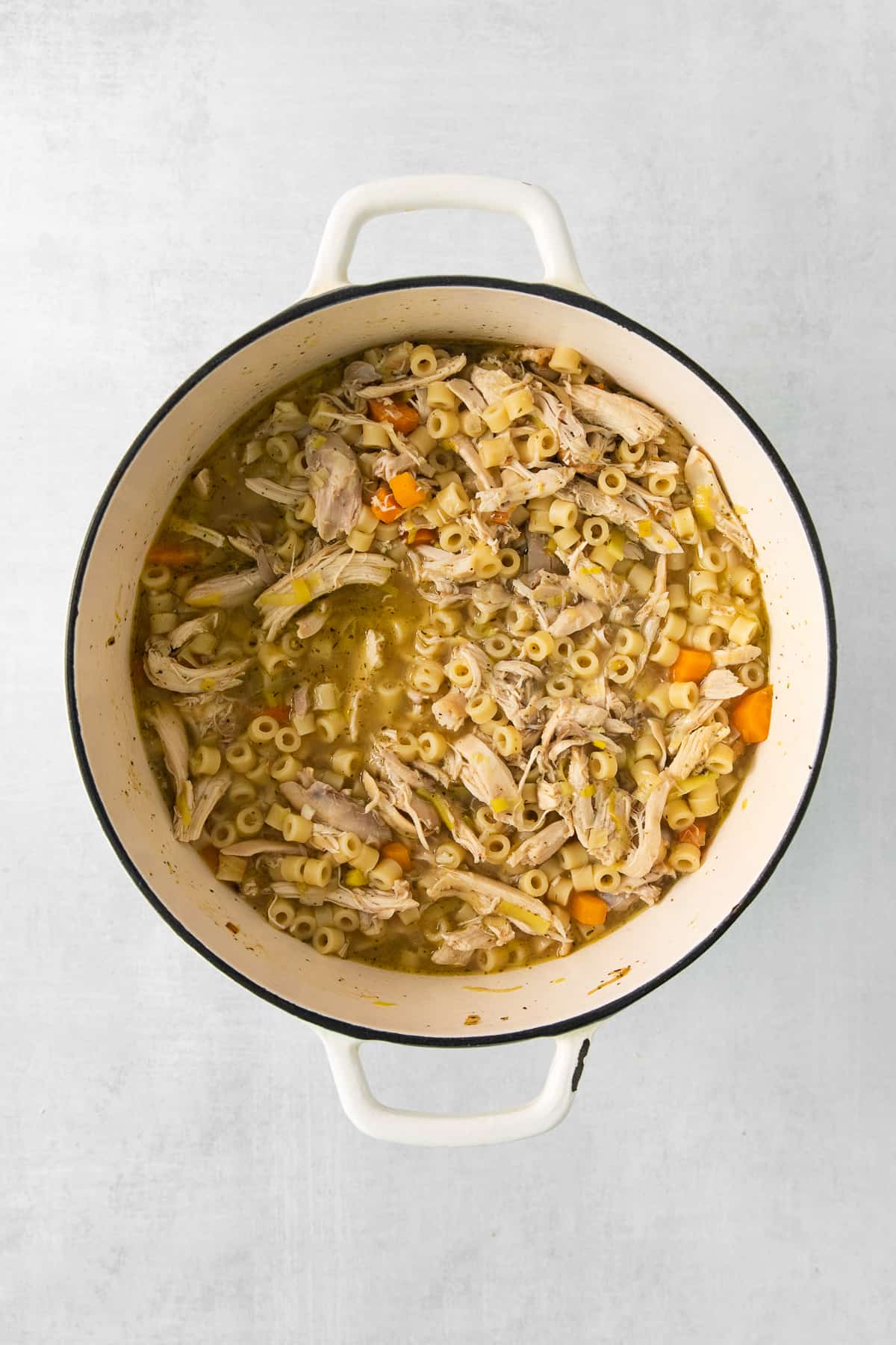 chicken noodle soup in a white pot.