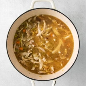 chicken soup in a pot on a white background.