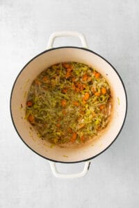 a pot filled with carrots and brussels sprouts.