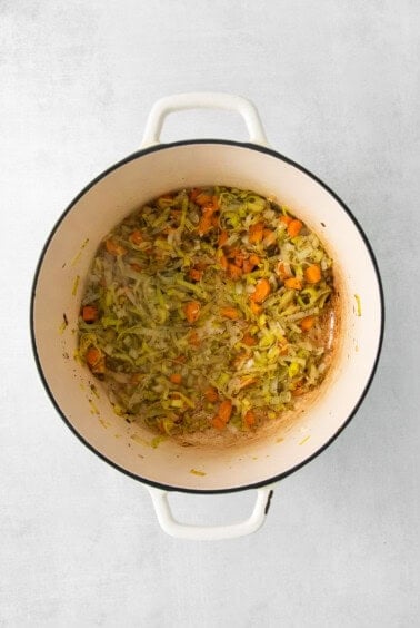 a pot filled with carrots and brussels sprouts.