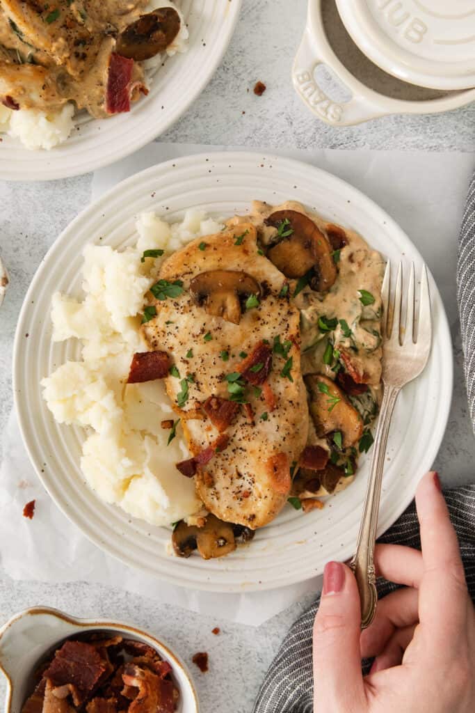 a plate of chicken with mushrooms and mashed potatoes.