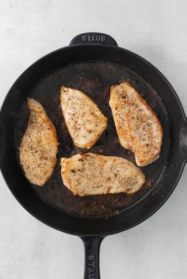chicken breasts in a cast iron skillet.