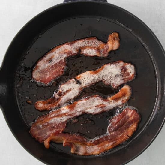 bacon in a skillet on a white background.