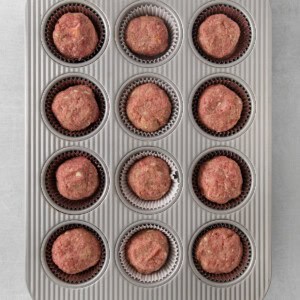 a muffin tin filled with meatballs.