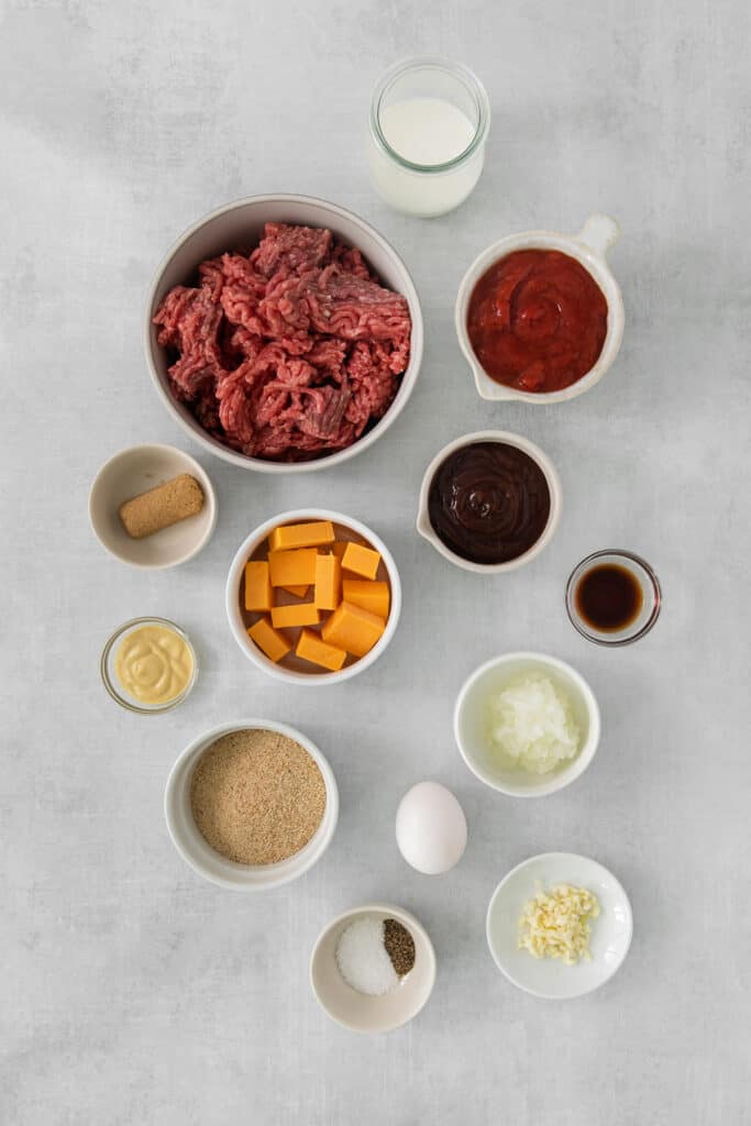 beef burger ingredients on a grey background.