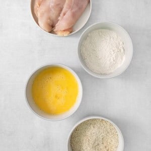 four bowls of ingredients for chicken fried rice.