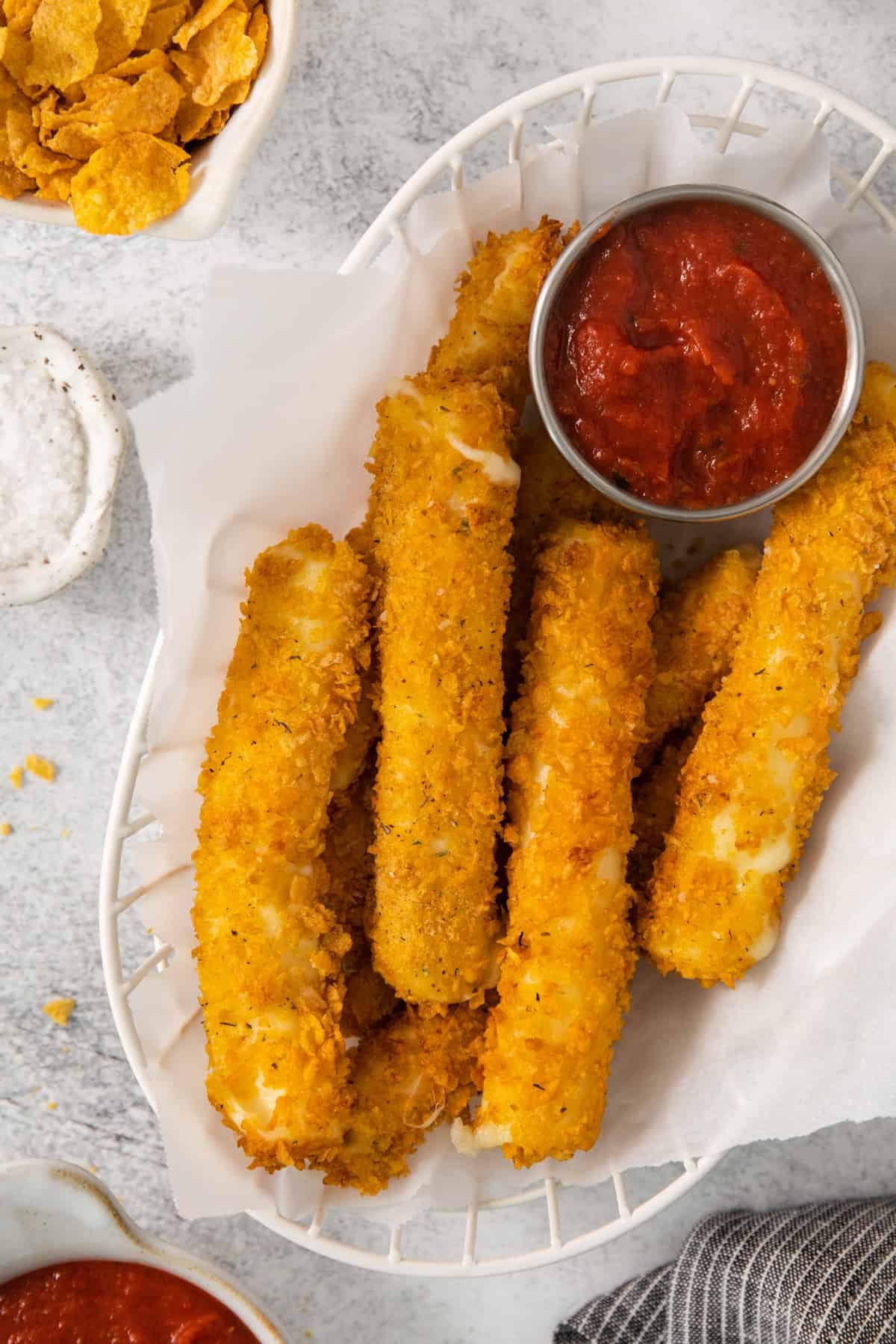 fried potato sticks in a basket with ketchup and dipping sauce.