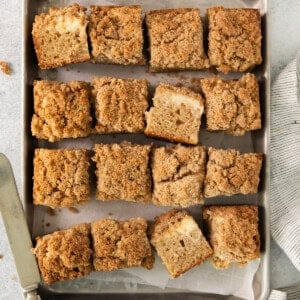 a pan filled with baked goods next to a cup of coffee.