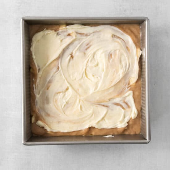 a pan filled with white frosting on top of a table.