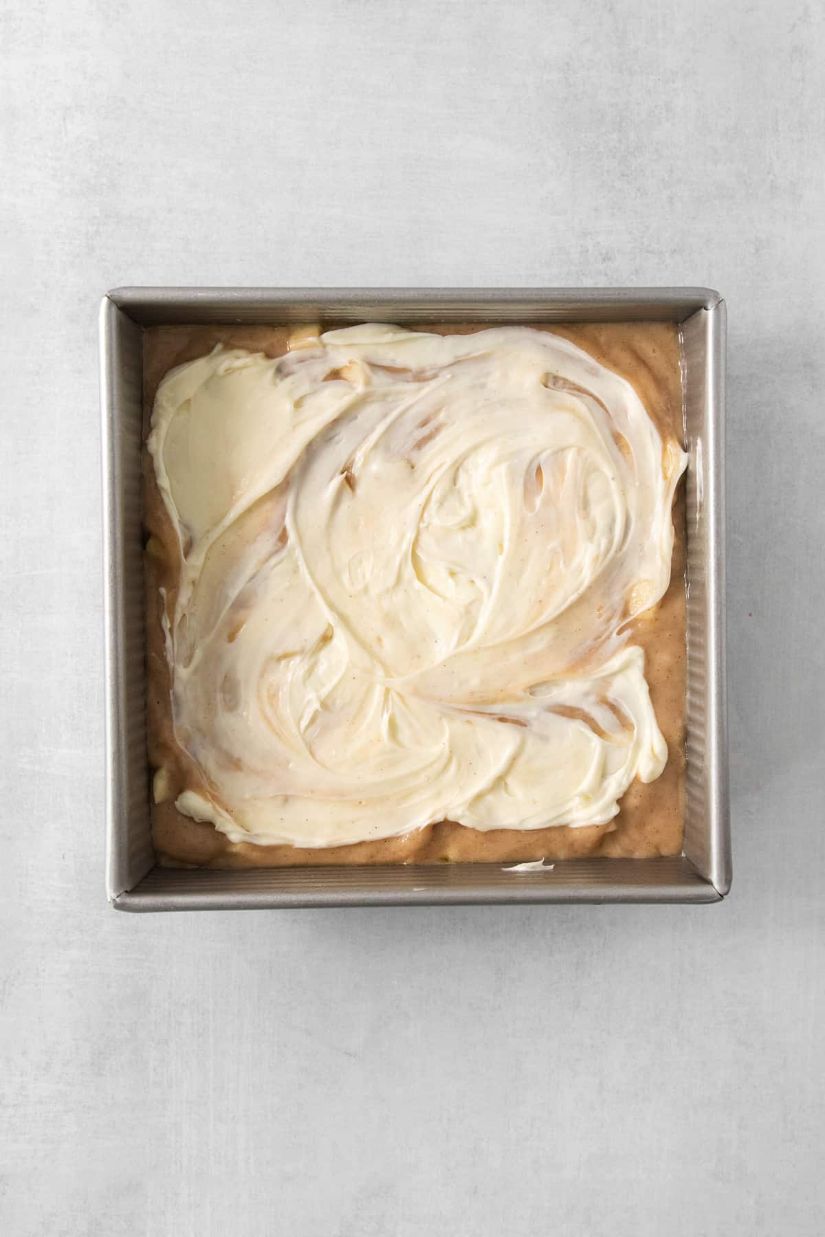 a pan filled with white frosting on top of a table.