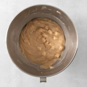 a metal bowl filled with peanut butter on top of a table.