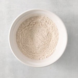 a white bowl filled with white powder on top of a table.