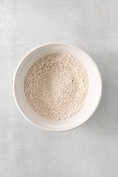 a white bowl filled with white powder on top of a table.