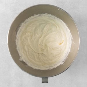 a bowl of whipped cream sitting on top of a table.