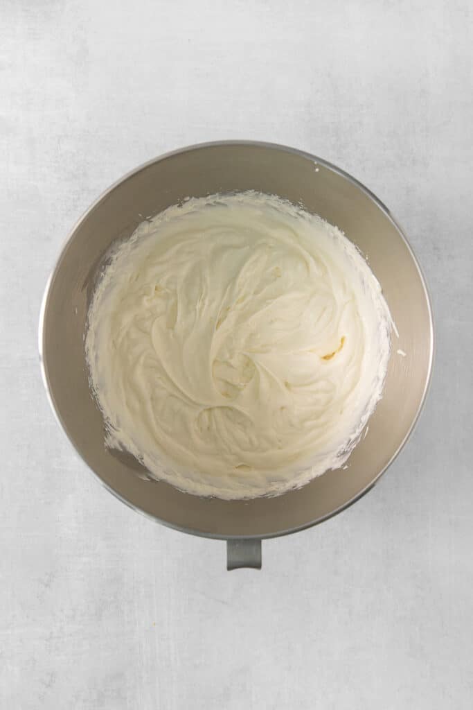 a bowl of whipped cream sitting on top of a table.