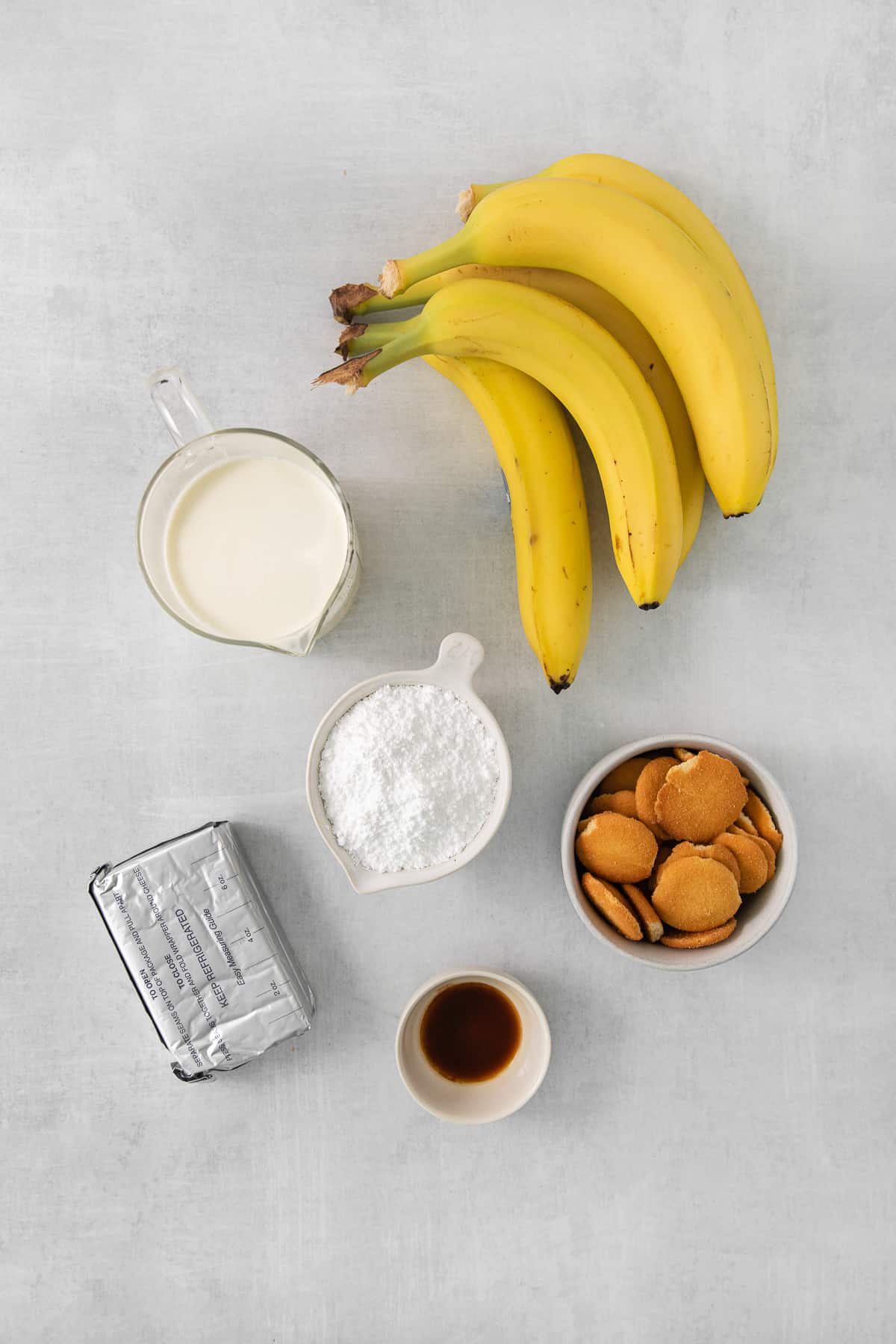 a bunch of bananas sitting next to a bowl of almonds.