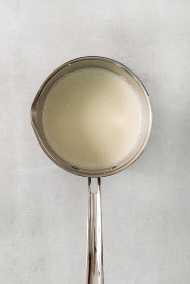 a metal spoon with a liquid inside of it.