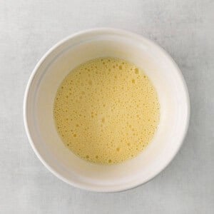 a white bowl filled with liquid on top of a table.