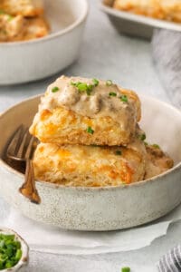 a stack of biscuits with gravy on a plate.