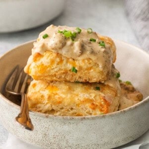 a stack of biscuits with gravy on a plate.