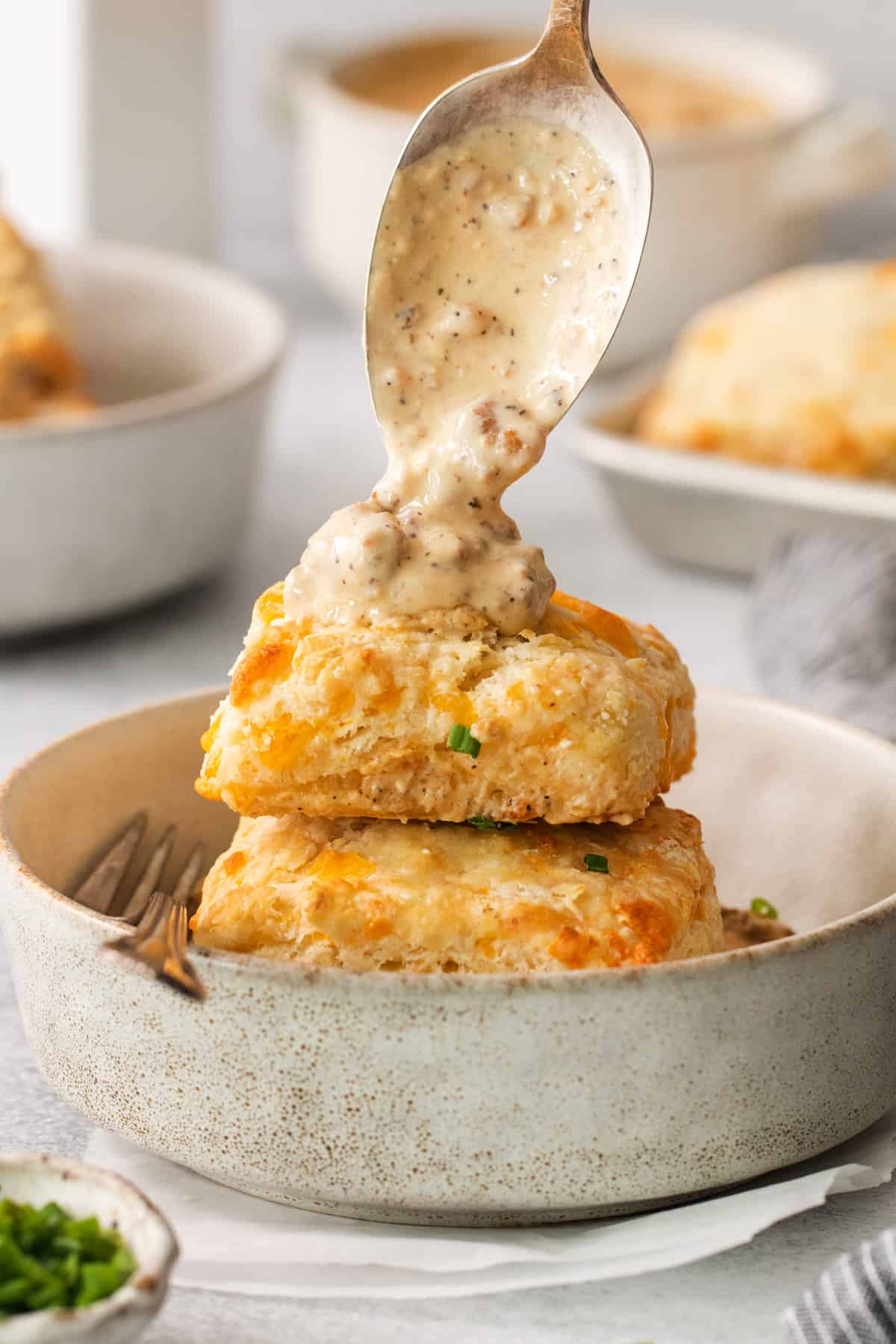 a plate of biscuits and gravy with a spoon.