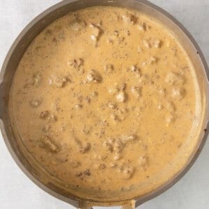 a skillet full of gravy with chicken in it.