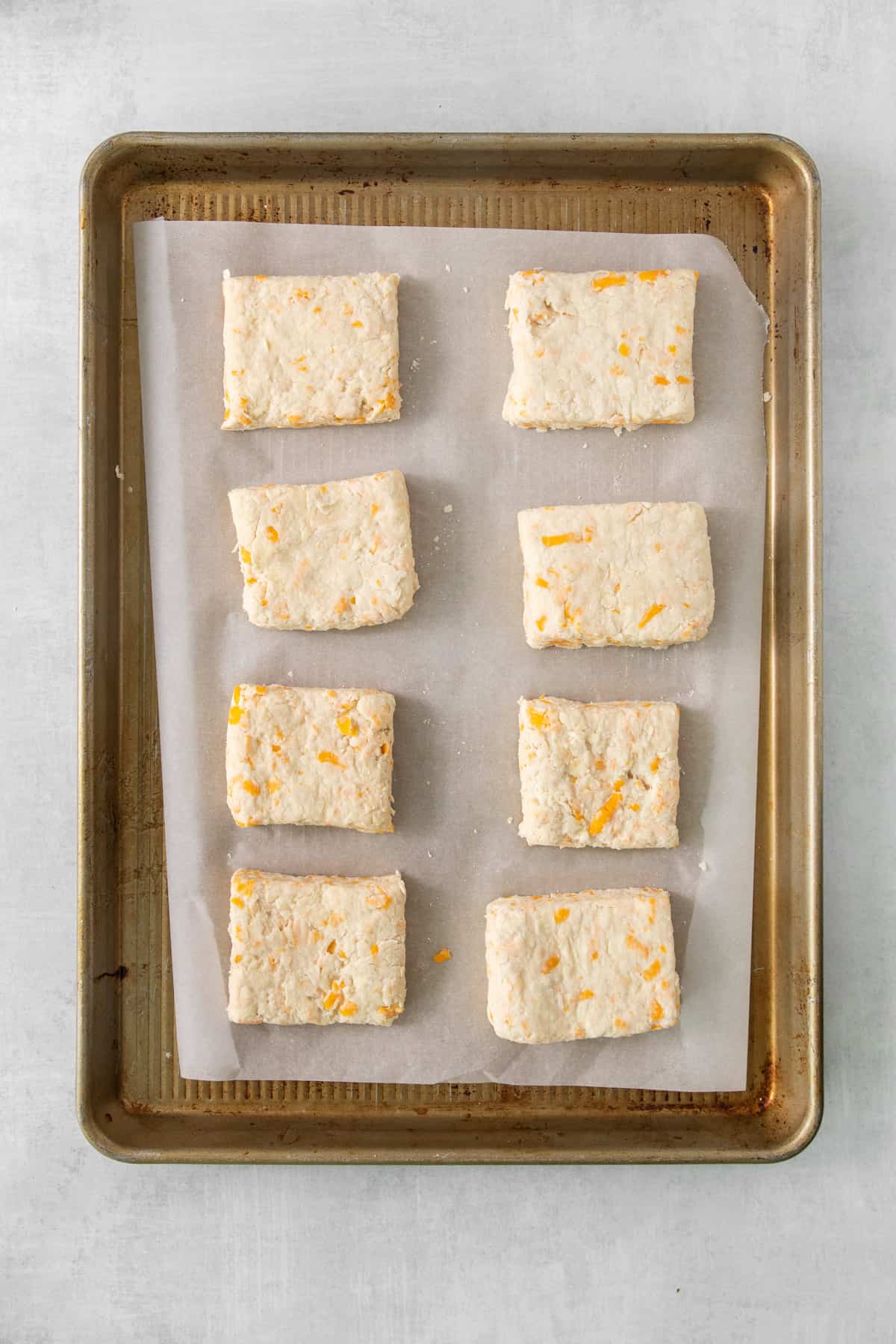 a baking sheet with a tray of cheese biscuits on it.