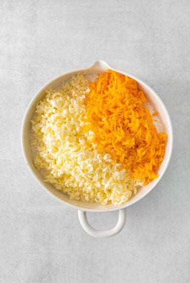 shredded cheese and carrots in a white bowl.
