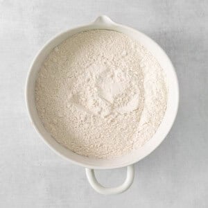 flour in a white bowl on a gray background.